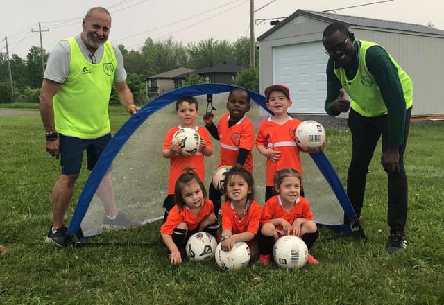 Soccer kids with balls at goal